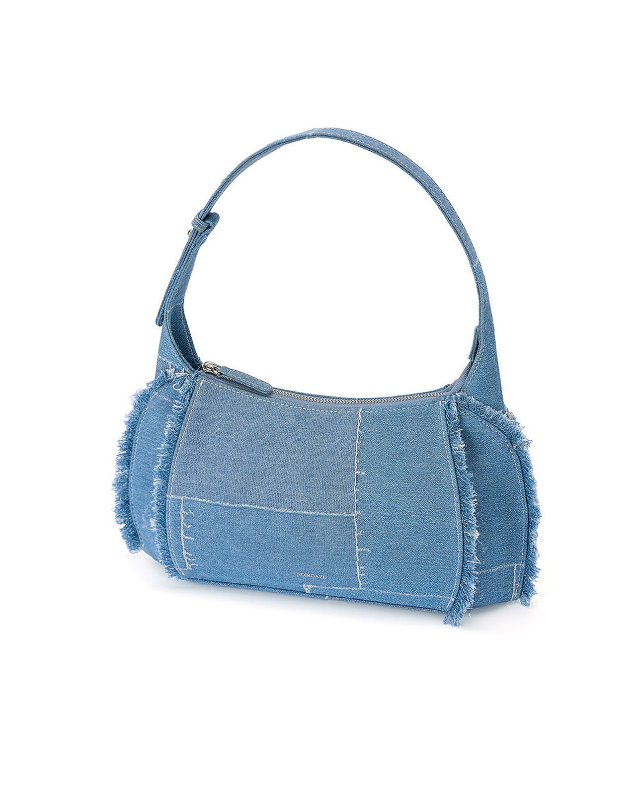 Skyler bag in denim shown from a three-quarter angle highlighting its patchwork design and frayed seams