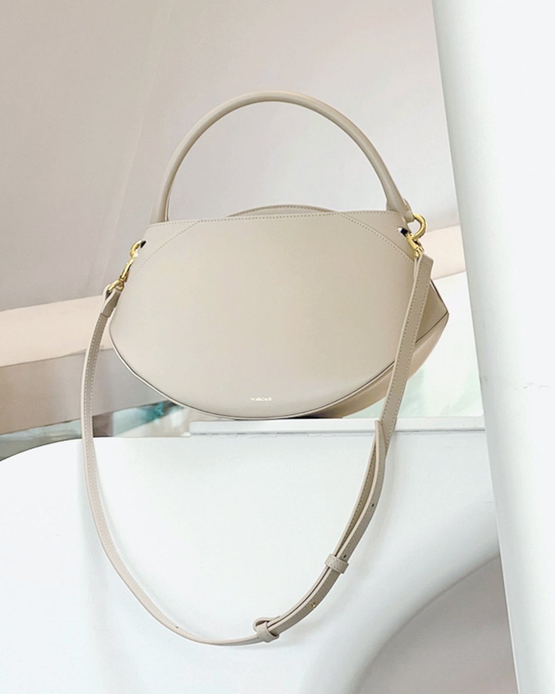 Sunrise Bag in Cream shown from a three-quarter angle highlighting its smooth leather texture and gold hardware